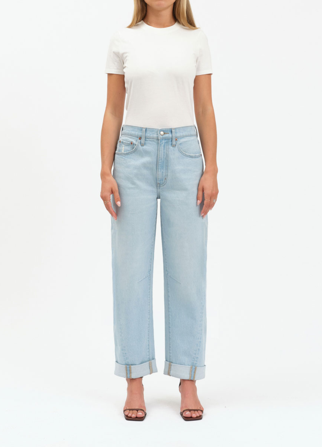 Person wearing a white t-shirt and light blue jeans on a white background